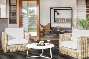 Relax in this serene outdoor seating area with two sofas and a small table, perfect for enjoying a quiet moment.