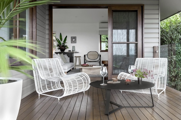 Relax in this serene outdoor seating area with a round table and two comfortable chairs.