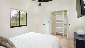 A bedroom with a bed, a wardrobe, a ceiling fan, and a window with a view of trees. - ` Velvet Bloom ` unique location 3mil to Downtown (Naples)
