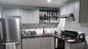 A modern kitchen with grey cabinets, stainless steel appliances, and a black countertop. - Wonderful Pondview Cottage in College Station (College Station)
