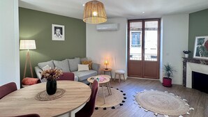 Una sala de estar moderna con comedor, sofá, mesa de centro y chimenea.