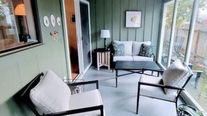 A balcony with a sofa, chairs, and a table. - Downtown Designer Duplex close to Beach! Spa Tub, Sunroom, Game Room, EV & more! (Long Beach)