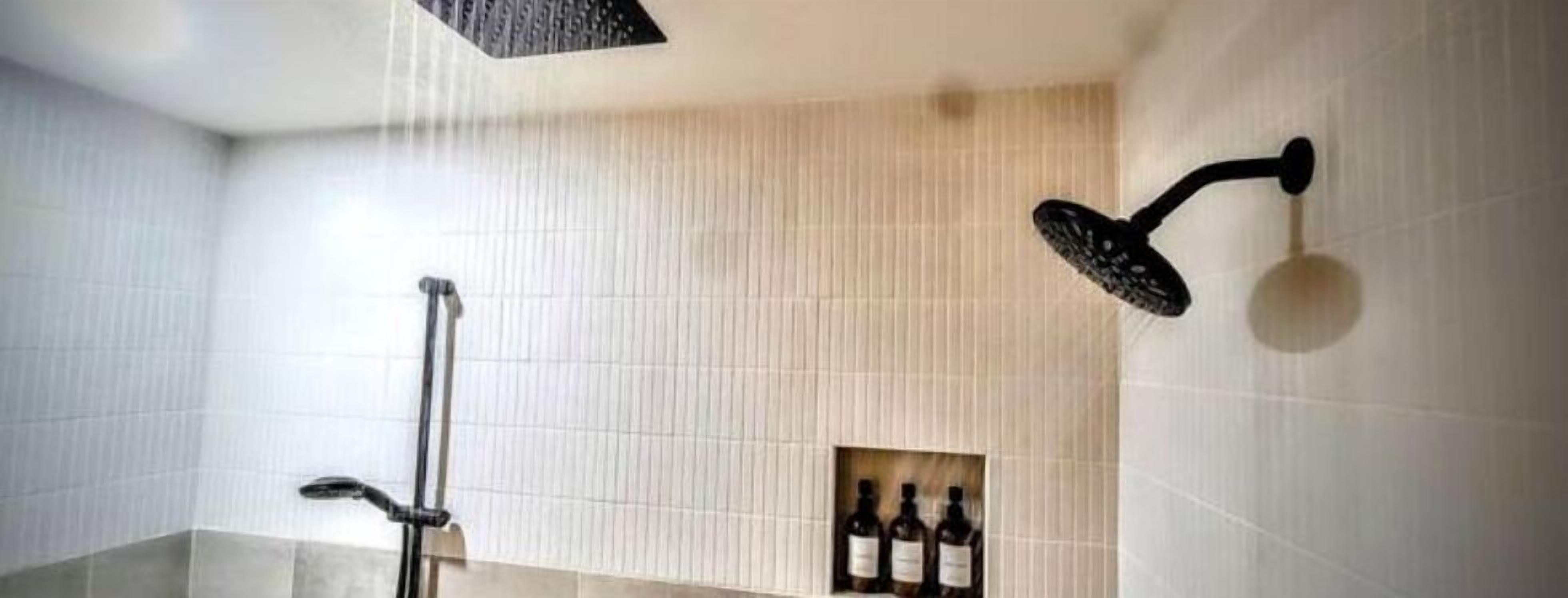 Ein modernes Badezimmer mit Dusche, Handtuchhalter und einer Shampoo-Flasche an der Wand.