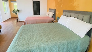 A hotel room with a large bed, a ceiling fan, and an air conditioning unit. - Bungalows Garza Blanca a Pie de Playa (San Blas)