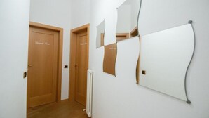 A hallway with two wooden doors labeled "Bedroom Room" and a white radiator on the wall.