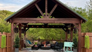 Un gazebo in legno con luci a stringa, mobili da esterno e una piscina.