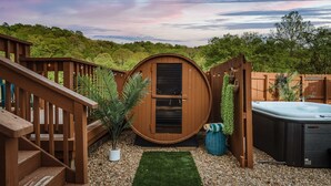 Una vasca idromassaggio, un pontile in legno e una piccola area giardino con un recinto in legno e una scala in legno.