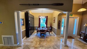 A spacious hallway with a marble floor, a round dining table with chairs, and a chandelier. - Casa Palmera: 3 bedroom home (Sebastian)