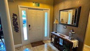 A lobby with a marble floor, an exit sign, a console table with a lamp, and a mirror on the wall. - Casa Palmera: 3 bedroom home (Sebastian)