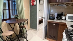 A compact kitchen with a dining area, a microwave, and a gas stove.