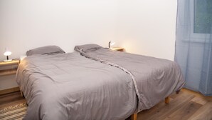A bedroom with a bed, bedside lamps, and a window with curtains. - Cosy apartment close to the center, parking &WiFi (Subotica)