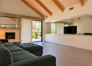 Una sala de estar moderna con un sofá modular, una chimenea y un televisor.