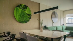 Un espace repas moderne avec une table ronde, des chaises et un canapé vert.