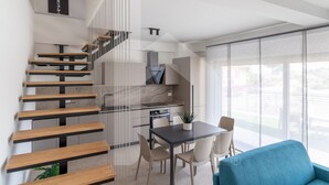 A modern interior with a spiral staircase, a dining area with a table and chairs, and a kitchen area. - Holiday home Elea will give you a holiday in Pineto but with the charm of a new modern building, fresh and designed with all the comforts. The Dafne apartment is the only one on two levels of the entire Elea complex, at the entrance a large living room w (Pineto)