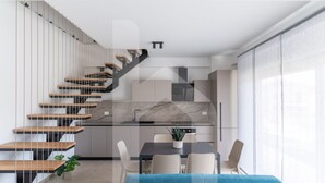 A modern kitchen with a marble countertop, a dining area with a blue sofa, and a staircase with wooden steps. - Holiday home Elea will give you a holiday in Pineto but with the charm of a new modern building, fresh and designed with all the comforts. The Dafne apartment is the only one on two levels of the entire Elea complex, at the entrance a large living room w (Pineto)