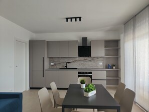 Enjoy meals in this stylish kitchen and dining area with a sleek range, ample seating for four, and a beautiful backsplash.