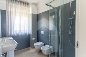 A modern bathroom with a glass shower enclosure, a toilet, and a bidet. - Holiday home ELEA is the 2025 novelty that will give you a holiday in Pineto but with the charm of a new modern construction, fresh and designed with all the comforts. he Clio apartment has a large living room with kitchenette and sofa bed at the entranc (Pineto)