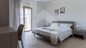A modern hotel room with a bed, bedside table, and a desk with a chair. - Holiday home ELEA is the 2025 novelty that will give you a holiday in Pineto but with the charm of a new modern construction, fresh and designed with all the comforts. he Clio apartment has a large living room with kitchenette and sofa bed at the entranc (Pineto)