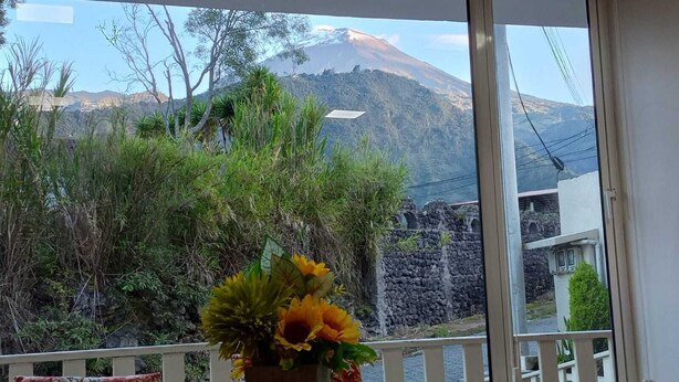A room with a large window overlooking a mountainous landscape.