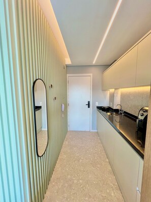 Cocina moderna con encimera, pileta y puerta que da a otra habitación.