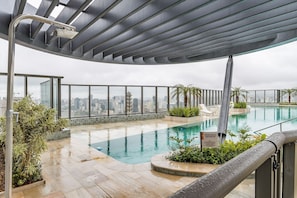 Une piscine sur le toit offrant une vue sur la ville, un espace couvert avec un toit en métal et un panneau indiquant une classification de deux étoiles.