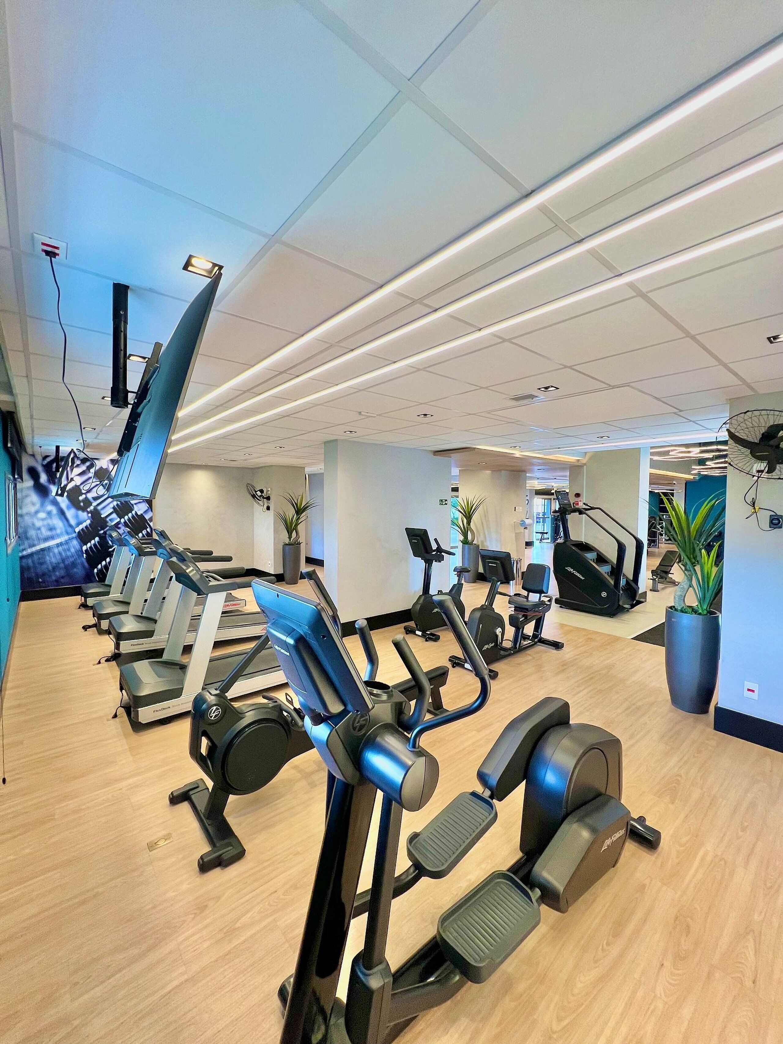 A gym with treadmills, elliptical machines, and stationary bikes.