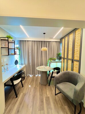 A modern living room with a dining area, a round table, and a grey armchair. - Innvista - AirBrooklin (São Paulo)