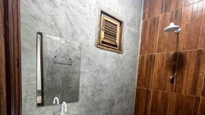 Un baño con lavabo blanco, inodoro, espejo y zona de ducha.