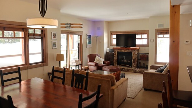 A cozy living room with a fireplace, a dining table, and comfortable seating.