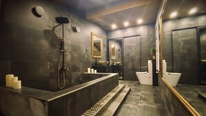 A modern bathroom with a large bathtub, a separate shower area, a vanity with a mirror, and a toilet. - WTF  HOUSE (Beograd)