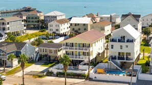 A coastal residential area with multiple two-story houses, a pier, and a swimming pool. - Beach House · Heated Pool + Private Elevator (Murrells Inlet)