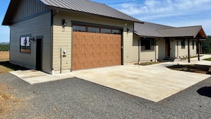 A single-story house with a garage, a covered porch, and a gravel driveway.
