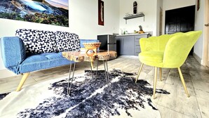 A modern living room with a blue sofa, a yellow chair, a rustic coffee table, and a black and white rug. - Charming chalet with WiFi in Poas. Great trails, and pools (Poas)