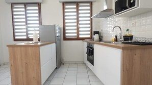 A compact kitchen with a wooden countertop, a built-in oven, a microwave, and a sink. - Le Carvinois, wifi, Carvin centre, 2pers (Carvin)