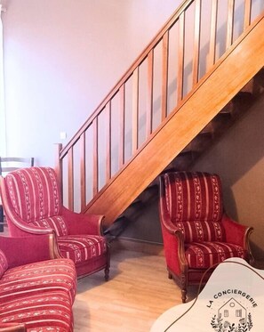 Step up to comfort in this inviting room, featuring a cozy reading nook with two plush armchairs and a stylish table.