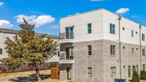Un bâtiment moderne à deux étages, doté d’un toit plat, de nombreuses fenêtres et d’un balcon à l’étage supérieur.