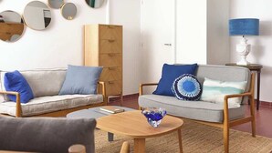 Un salon avec deux canapés, une table basse et une lampe.