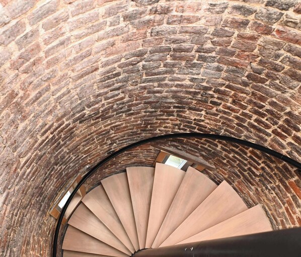 Eine Wendeltreppe vor einer Backsteinwand.