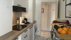 A compact kitchen with a coffee maker, a washing machine, and a fruit basket. - Saint-Raphael, near the TGV station, shops, Old Port and beach, large T2 50m2, 4 people, very well equipped and parking (Saint Raphael)