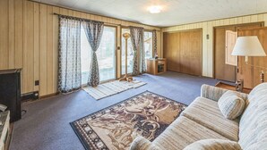 A cozy living room with a sofa, a rug, and a lamp. - Twice Upon A Lake : Summer Retreat for the Whole Family (Curran)