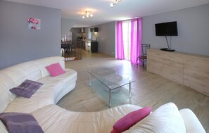 Relax in this stylish living room with a comfortable sofa, coffee table, and flat-screen TV.