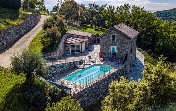 Escape to a secluded villa surrounded by lush greenery and a pool.