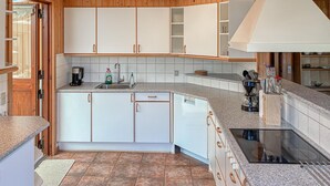 A modern kitchen with white cabinets, a granite countertop, and a built-in stove. - Awesome home in Væggerløse with WiFi (Væggerløse)