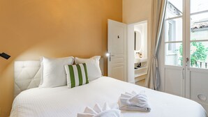 Une chambre d’hôtel avec un lit, des oreillers, une fenêtre et une porte donnant sur une salle de bain.