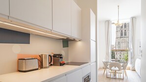 Une cuisine moderne équipée d’un grille-pain, d’une bouilloire et d’une machine à café. Un coin repas avec une table et des chaises est également à disposition.