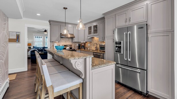 A modern kitchen with stainless steel appliances, light grey cabinetry, and a central island with bar stools. - 2Blocks 2Beach | Free Coffee | Linens+Towels | AC (Belmar)