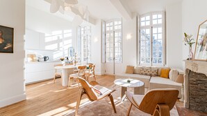 Un grand espace de vie comprenant une table à manger, des chaises, un canapé et une cheminée.
