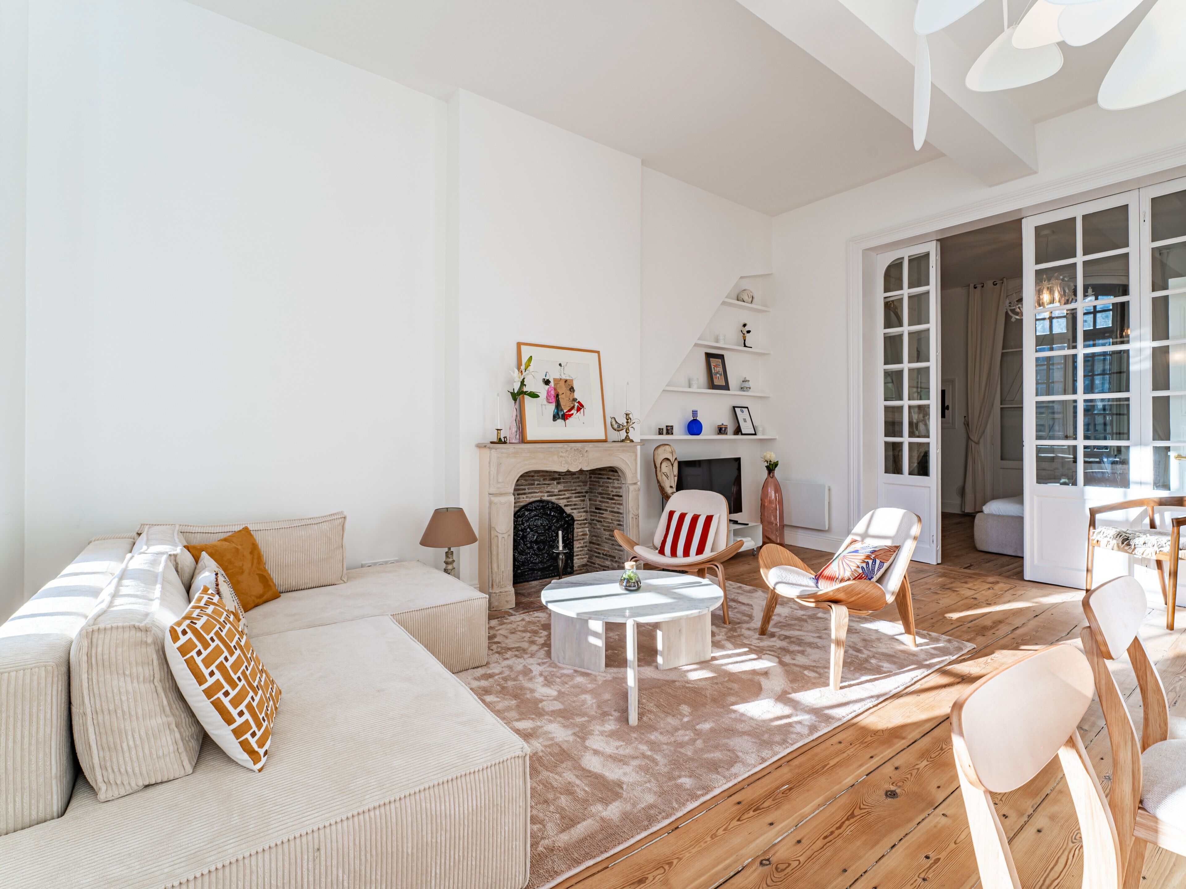 Un salon spacieux avec un grand canapé, une cheminée et un coin repas équipé de chaises.