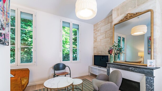 A living room with a fireplace, a TV, a sofa, and a dining table.