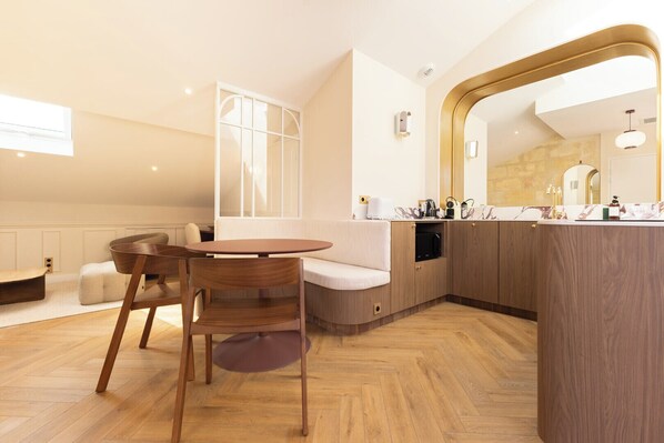 A modern kitchen with a wooden countertop, a built-in oven, and a large mirror above the sink.